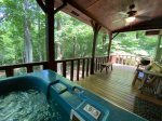 Main floor porch with a hot tub and charcoal grill 